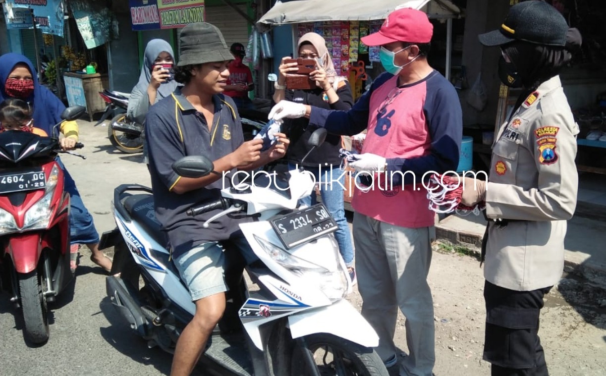 MASKER - Plt Camat Wonoayu, Gundari bersama Kapolsek Wonoayu, AKP Rohmawati Lailah membagikan masker kepada para pengguna jalan yang melintas di Pasar Kaget Jimbaran Kulon, Kecamatan Wonoayu, Sidoarjo, Minggu (28/06/2020).