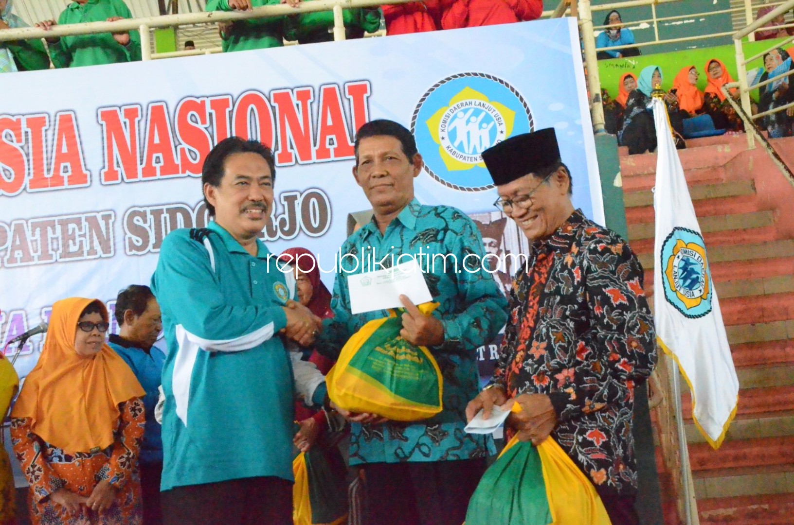 BINGKISAN - Wabup Sidoarjo, Nur Ahmad Syaifuddin didampingi pengurus Komda lansia Provinsi Jatim dan Sidoarjo memberikan bingkisan secara simbolis kepada para Lansia di GOR Sidoarjo, Sabtu (20/07/2019).