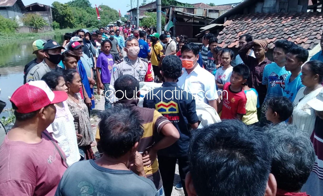 EVAKUASI - Abdul Halim ayah kandung korban, Irawati (9) warga Kelurahan Wonocolo, Kecamatan Taman, Sidoarjo mengevakuasi dan menggendong putrinya yang dinyatakan sudah meninggal dunia akibat terjebur sungai, Senin (03/08/2020).