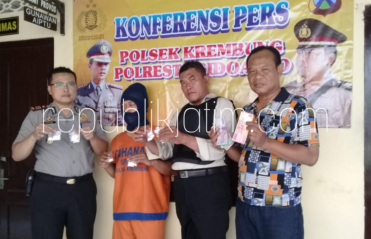 PENGEDAR - Kapolsek Krembung, AKP Guntoro (kiri) menunjukkan tersangka peredaran pil double L, M Ridwan (tengah) beserta barang bukti 340 butir pil siap edar, Minggu (05/08/2018).