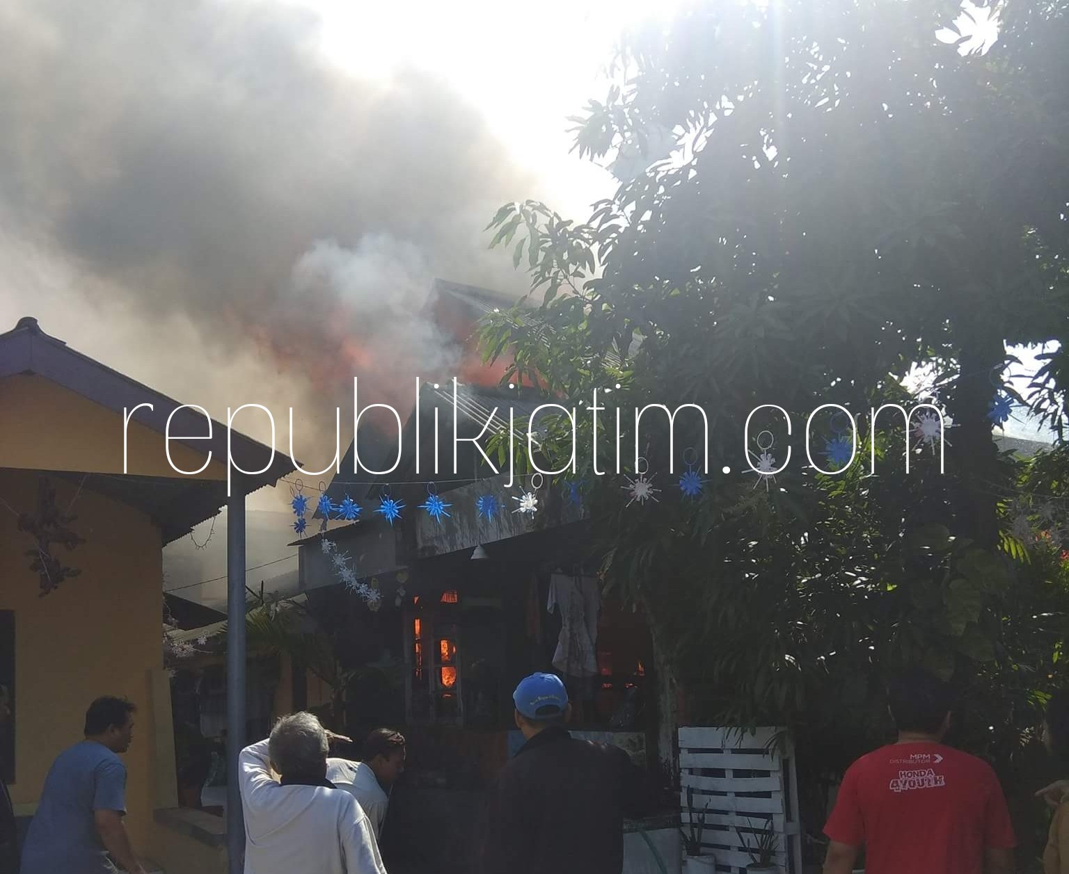 TERBAKAR - Sejumlah warga Desa/Kecamatan Gedangan, Sidoarjo sibuk memadamkan api yang membakar rumah milik Muhammad Maskur (48) dan dapur rumah Miswanto (50) yang diduga dipicu hubungan arus pendek (korsleting), Kamis (09/08/2018).