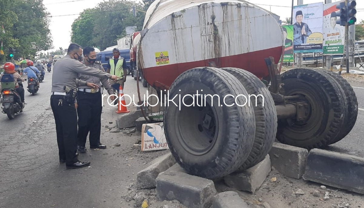EVAKUASI - Sejumlah anggota Lantas Polsek Balongbendo menggelar olah TKP Truk Tangki yang patah di perempatan Pos Polisi JL Raya Surabaya-Mojokerto, Desa Bakalan, Kecamatan Balongbendo, Sidoarjo, Selasa (11/08/2020) sore.