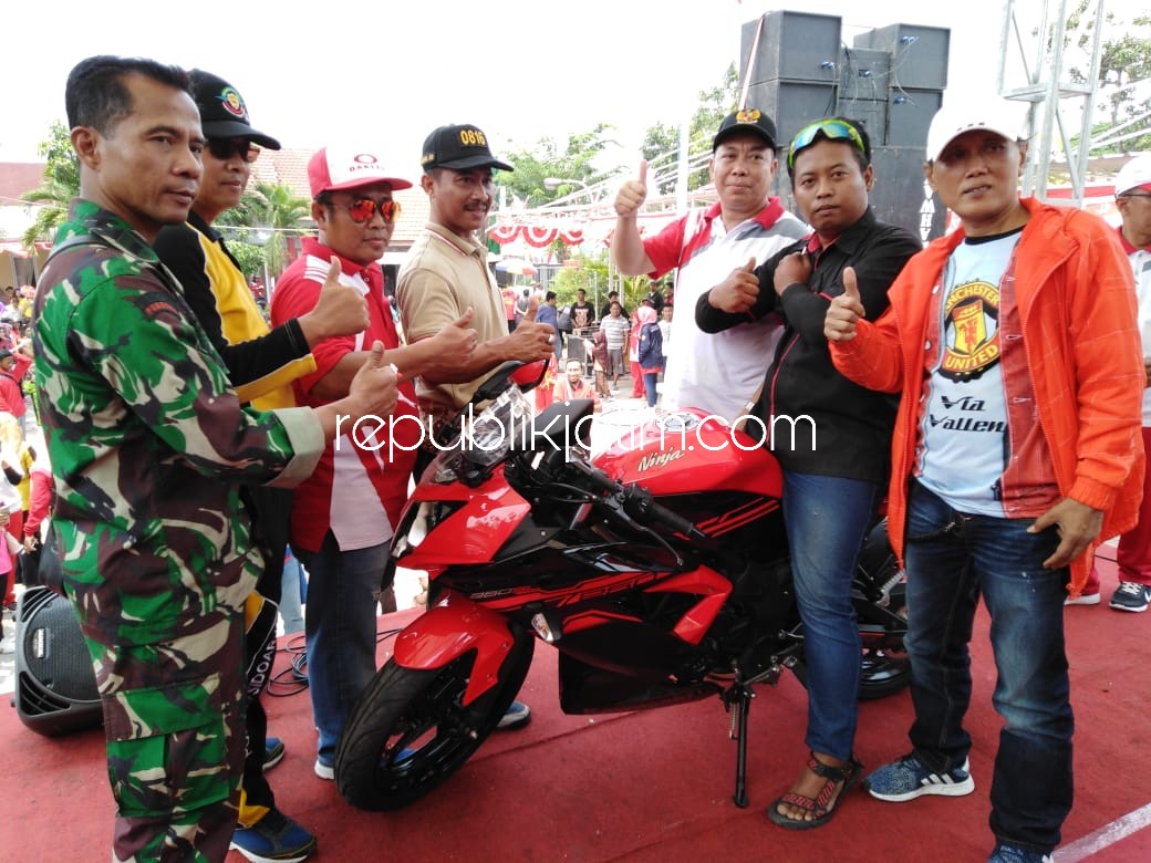 GRAND PRICE - Camat Tanggulangin, Didik Widoyoko bersama M Arifin (kanan) ayah kandung Via Vallen menyerahkan Grand Price 1 unit motor Kawasaki Ninja 250 CC kepada Niko Vebri peserta jalan sehat, Sabtu (01/09/2018).