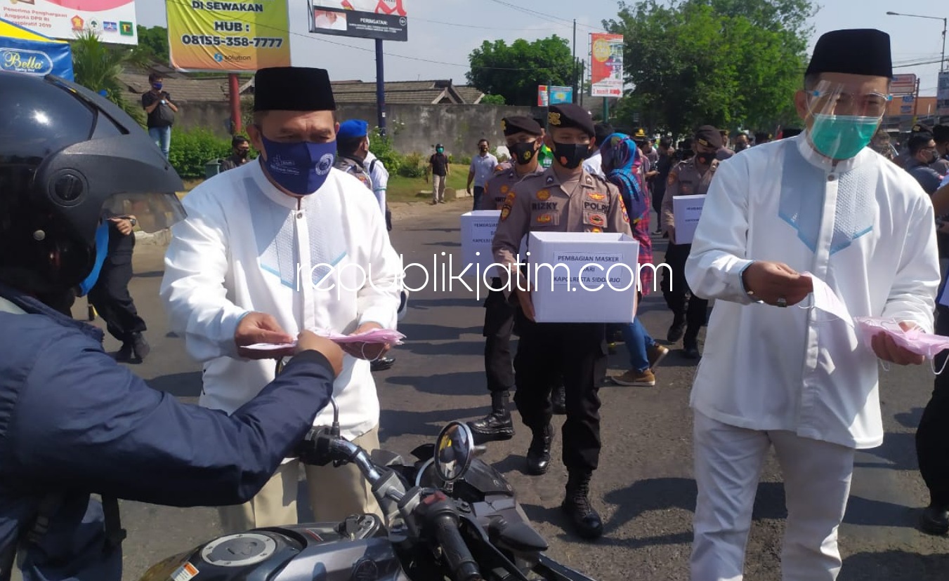 BAGIAN MASKER - Tiga Pasangan Calon (Paslon) Bupati dan Wakil Bupati membagikan 42.000 masker untuk pengguna jalan di pertigaan Cemengkalang, Kecamatan Sidoarjo, Kamis (10/09/2020).