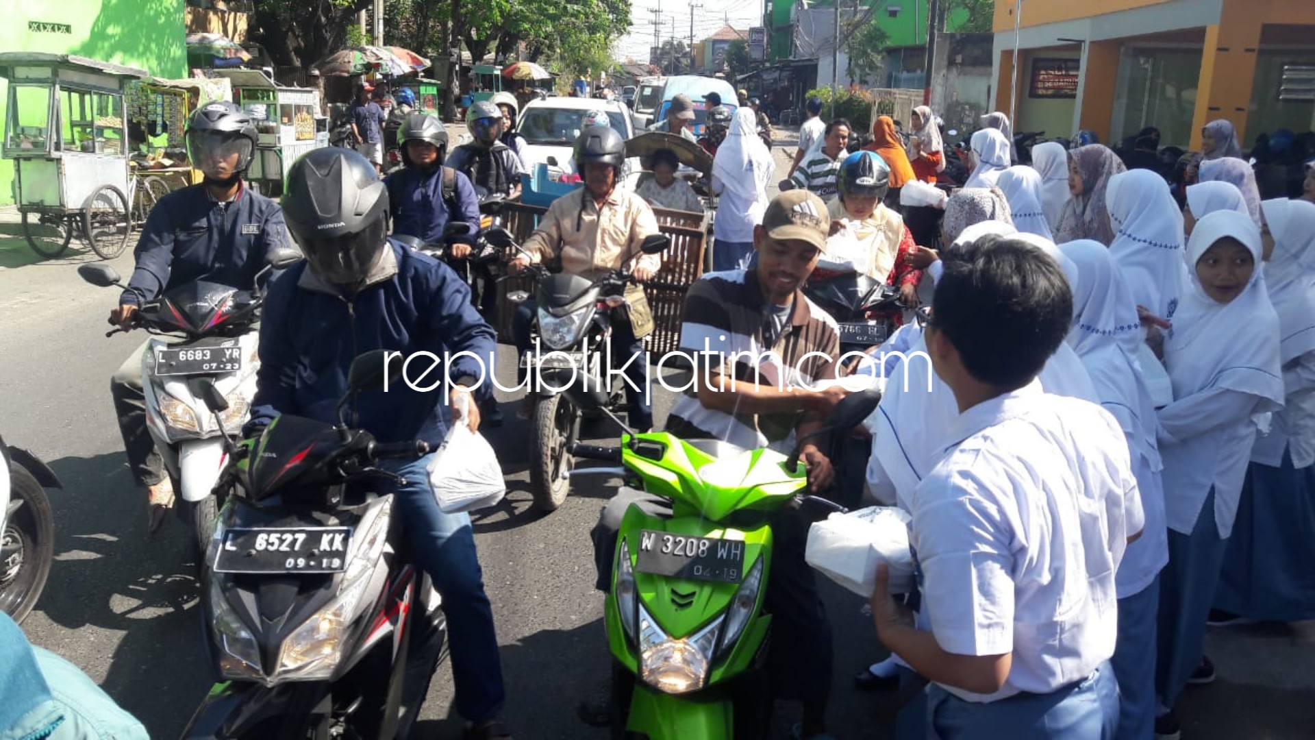 BERBAGI - Ratusan siswa Smamita membagikan 1001 nasi kotak ke pengguna jalan, warga sekitar dan para pedangan Pasar Sepanjang, Kecamatan Taman, Sidoarjo, Senin (10/09/2018).