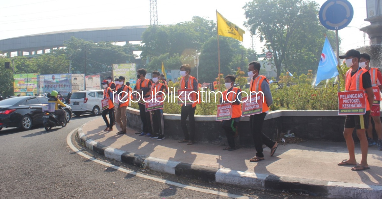 ROMPI - 25 orang terjaring razia tertib dan disiplin bermasker yang digelar personel gabungan TNI-Polri, Satpol PP dan Dinas Perhubungan (Dishub) Pemkab Sidoarjo dihukum berdiri pakai rompi orange di Bundaran Taman Pinang Indah (TPI), Minggu, (13/09/2020)
