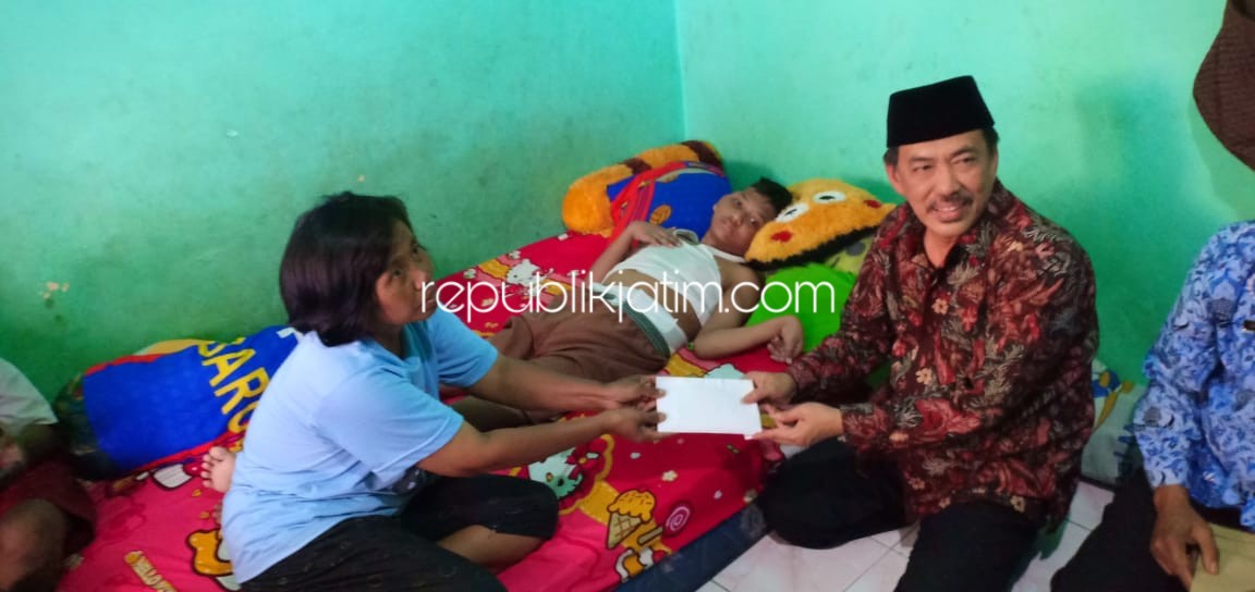 PERHATIAN - Wabup Sidoarjo, Nur Ahmad Syaifuddin memberikan perhatian kepada Dimas Satria Wijaya (14) yang terbaring diranjangnya di kamar kos Desa Kedungrejo, Kecamatan Waru agar segera ditangani tim medis, Selasa (17/09/2019).