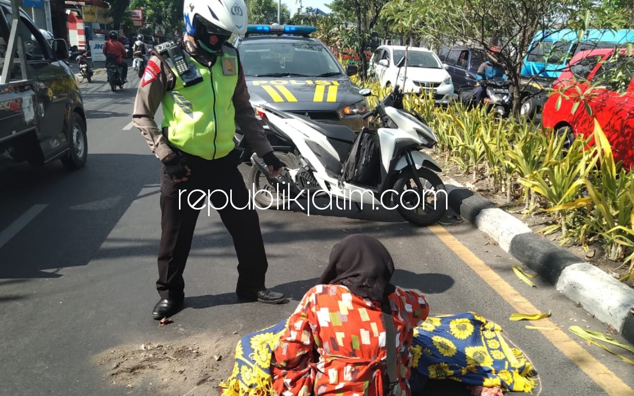 EVAKUASI - Petugas mengevakuasi jenazah, Ny Hartik (54) warga Keputran Pasar Kecil, Kecamatan Tegalsari, Surabaya yang tewas terlindas truk di JL Raya Desa/Kecamatan Buduran, Sidoarjo, Senin (12/10/2020).