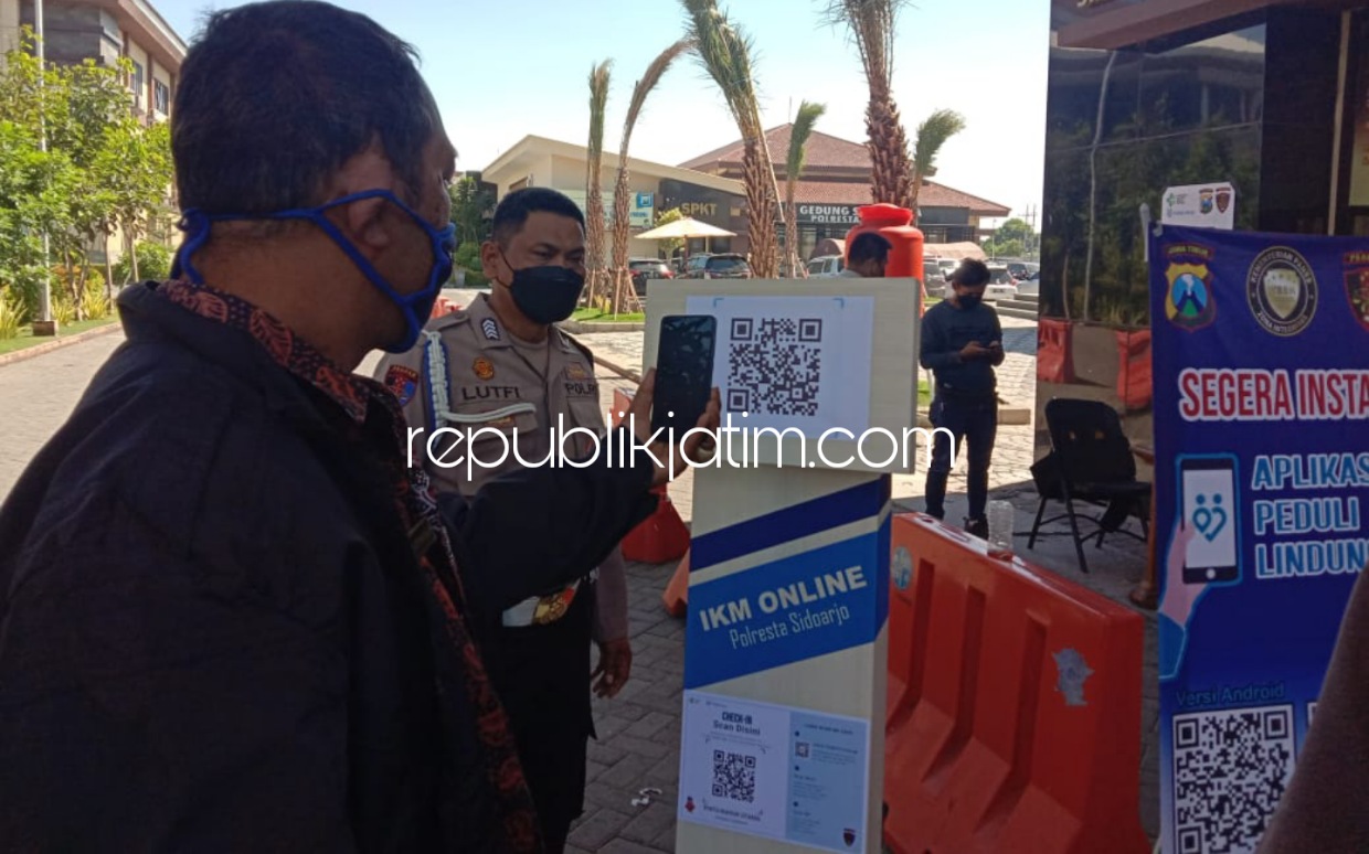 APLIKASI - Tidak hanya masyarakat umum, anggota TNI dan Polri, saat masuk ke Polresta Sidoarjo harus scan QR Code pada aplikasi PeduliLindungi, dengan terlebih dulu mengunduh aplikasi di smartphone, Selasa (13/10/2021).