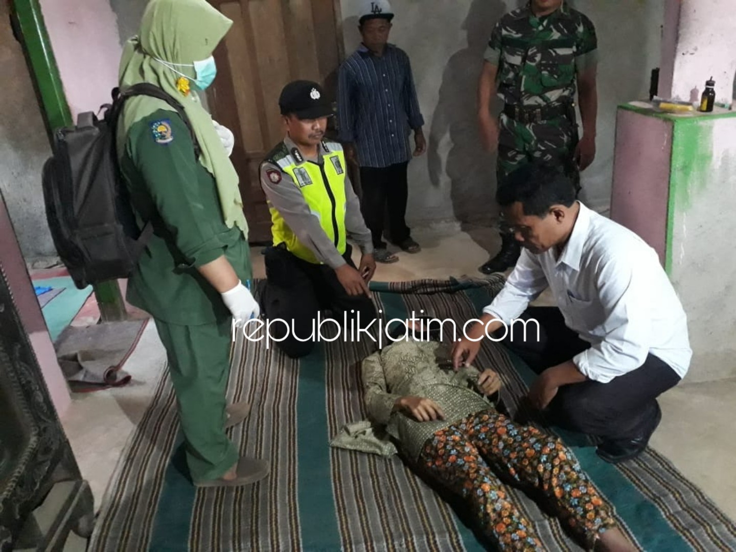 TEWAS - Petugas mengevakuasi korban gantung diri Ny Sarbani (78) warga Dusun Petung, Desa Binade, Kecamatan Ngrayun, Ponorogo yang tewas gantung diri, Senin (15/10/2018).