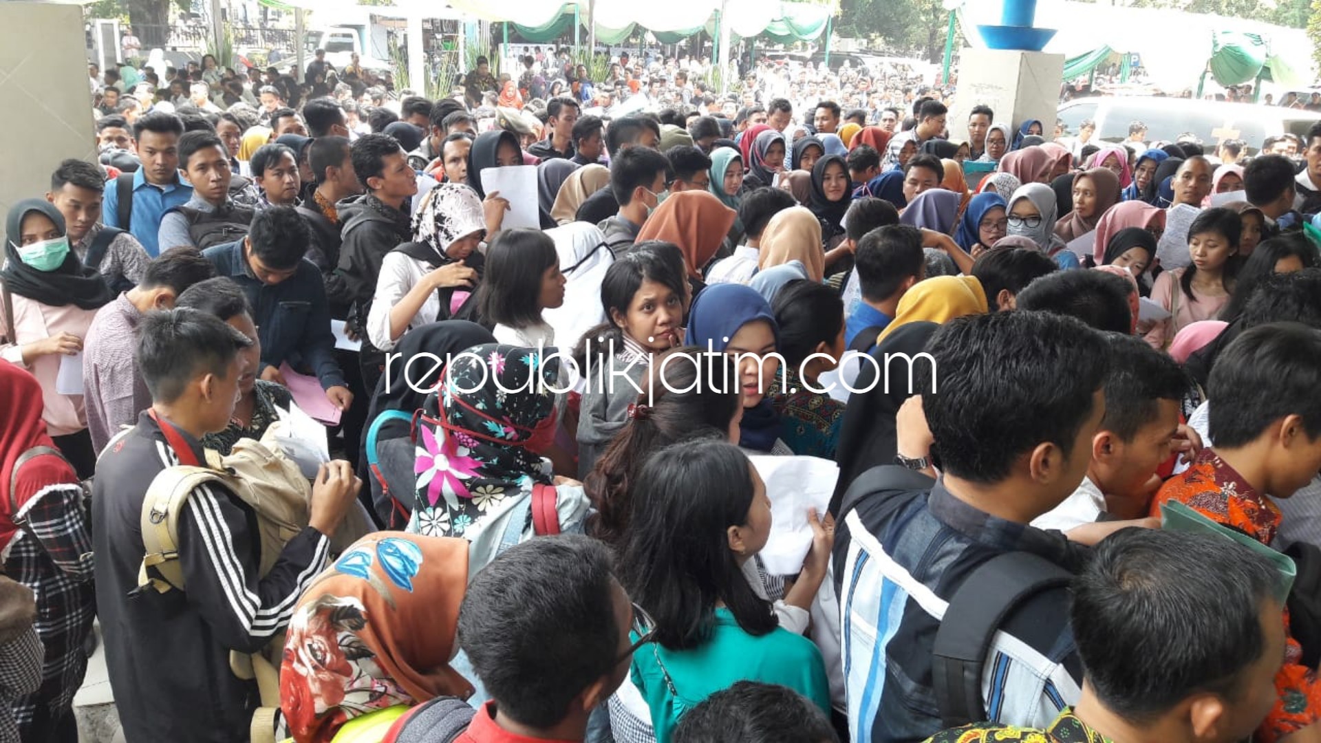 ANTRE MASUK - Ribuan para pencari kerja mengantre di depan pintu masuk lapangan Indoor Tenis GOR Sidoarjo untuk melamar ke 58 perusahaan yang membuka lowongan dalam acara Job Fair Tahun 2018, Selasa (16/10/2018).