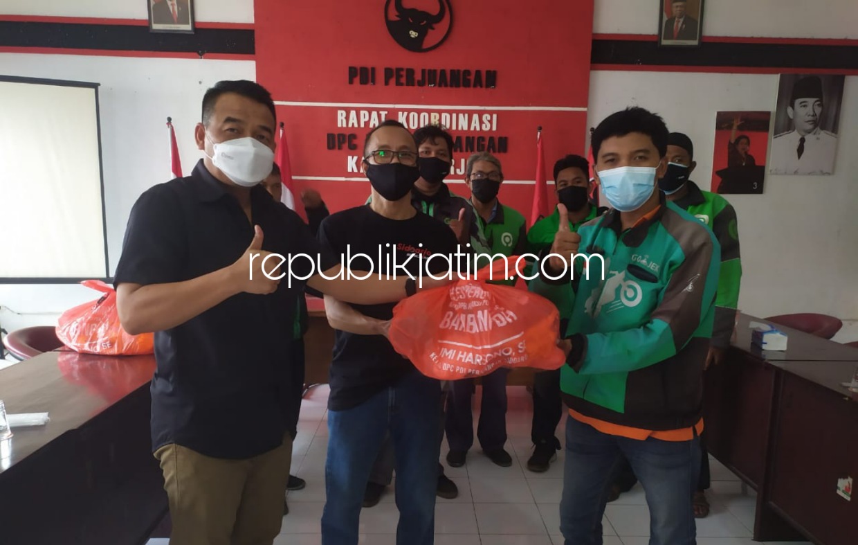 SERAHKAN - Ketua DPC PDI Perjuangan Sidoarjo, Sumi Harsono menyerahkan bantuan paket sembako rises anggota Komisi III DPR RI, Bambang DH kepada perwakilan penarik Ojok Online (Ojol) di kantor DPC PDI Perjuangan, Sidoarjo, Selasa (19/10/2021).
