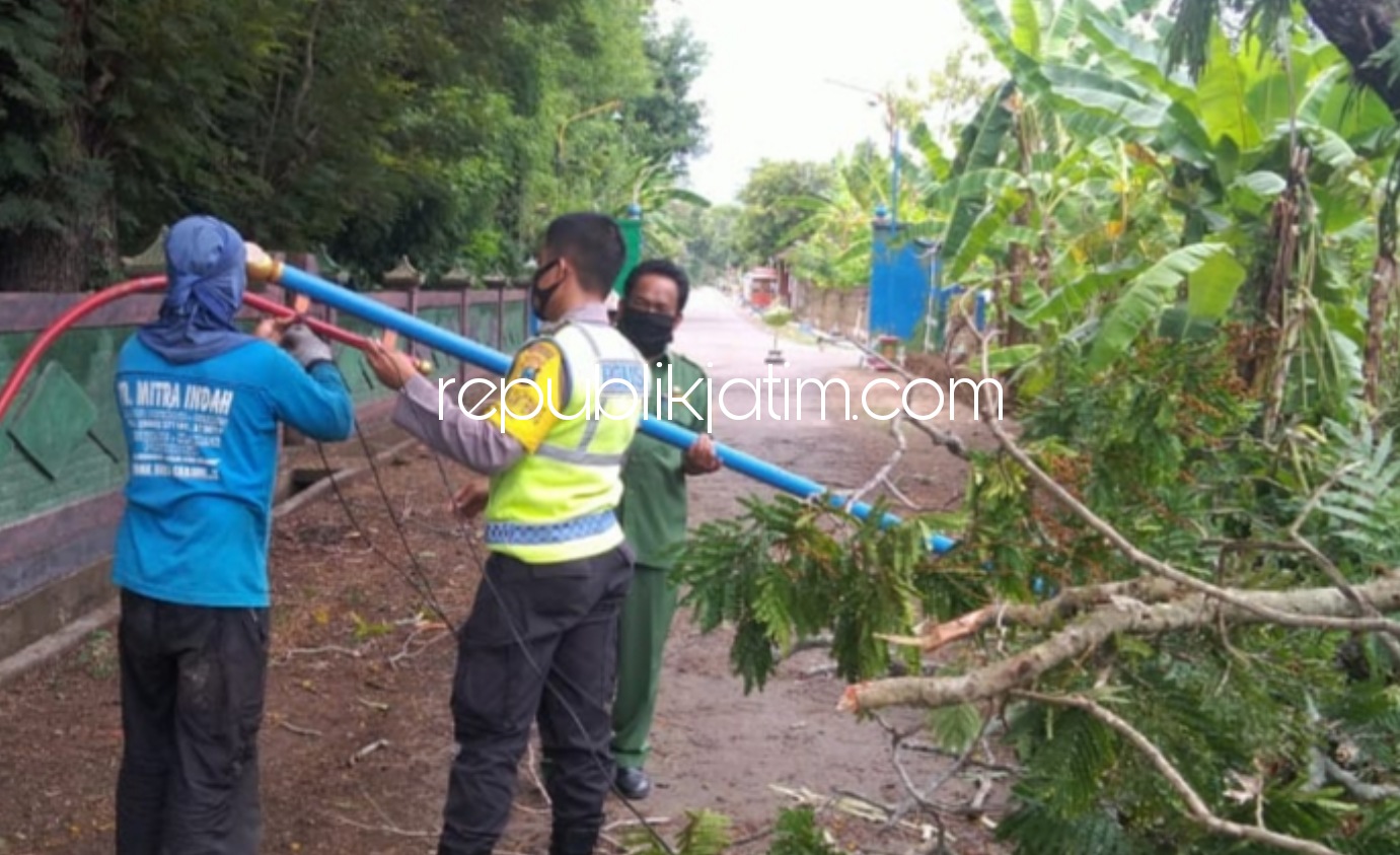 EVAKUASI - Anggota Polsek dibantu warga mengevakuasi pohon tumbang dan membenahi tiang listrik yang roboh di Desa Gundik, Kecamatan Slahung, Ponorogo, Senin (02/11/2020).