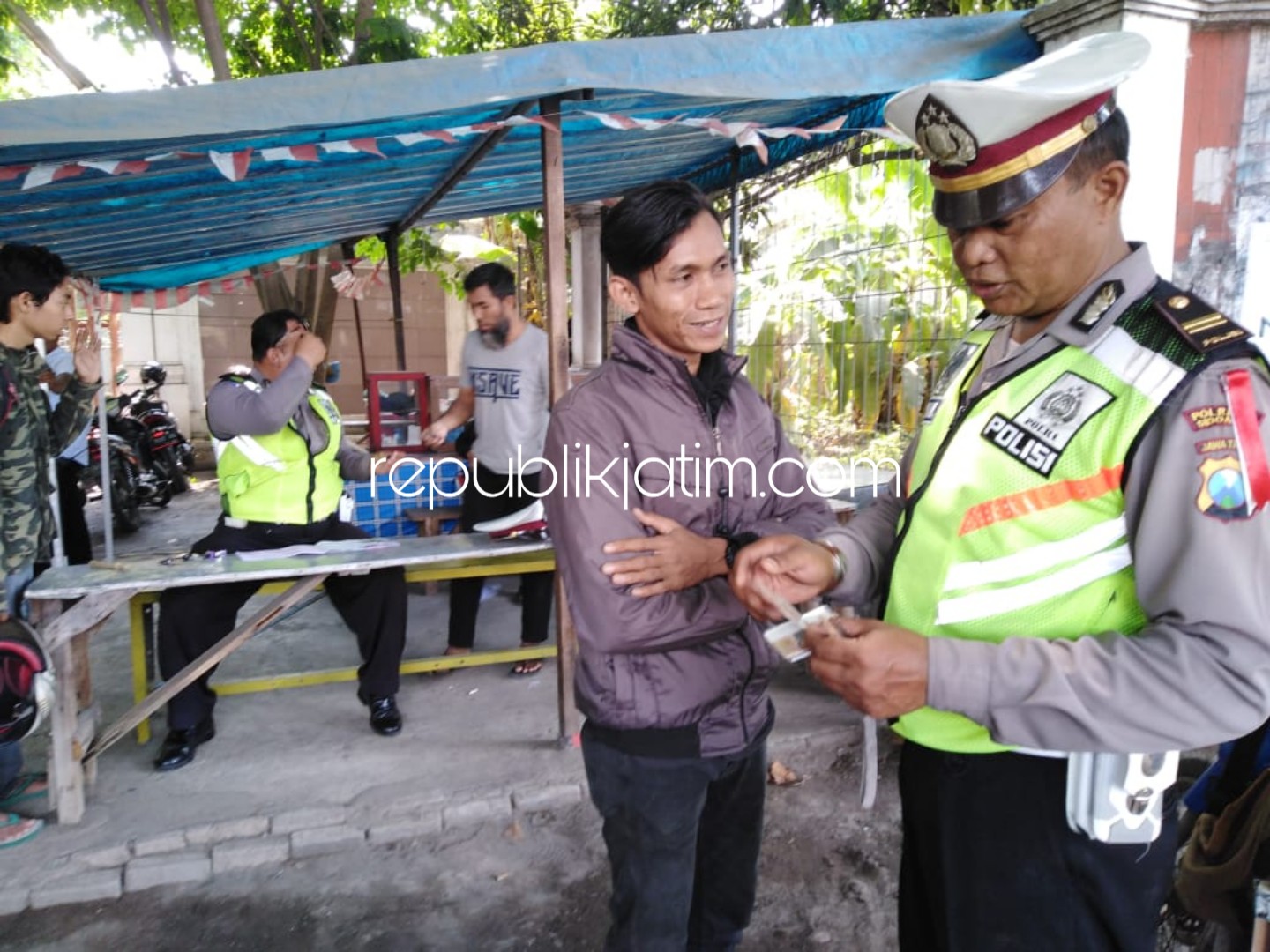 PENJELASAN - Kanit Lantas Polsek Tanggulangin, Iptu Agus Hermanto kanan memberikan penjelasan dan pemahaman kepada Pramo Wardani yang enggan ditilang saat razia di Tanggulangin, Kamis (01/11/2018).