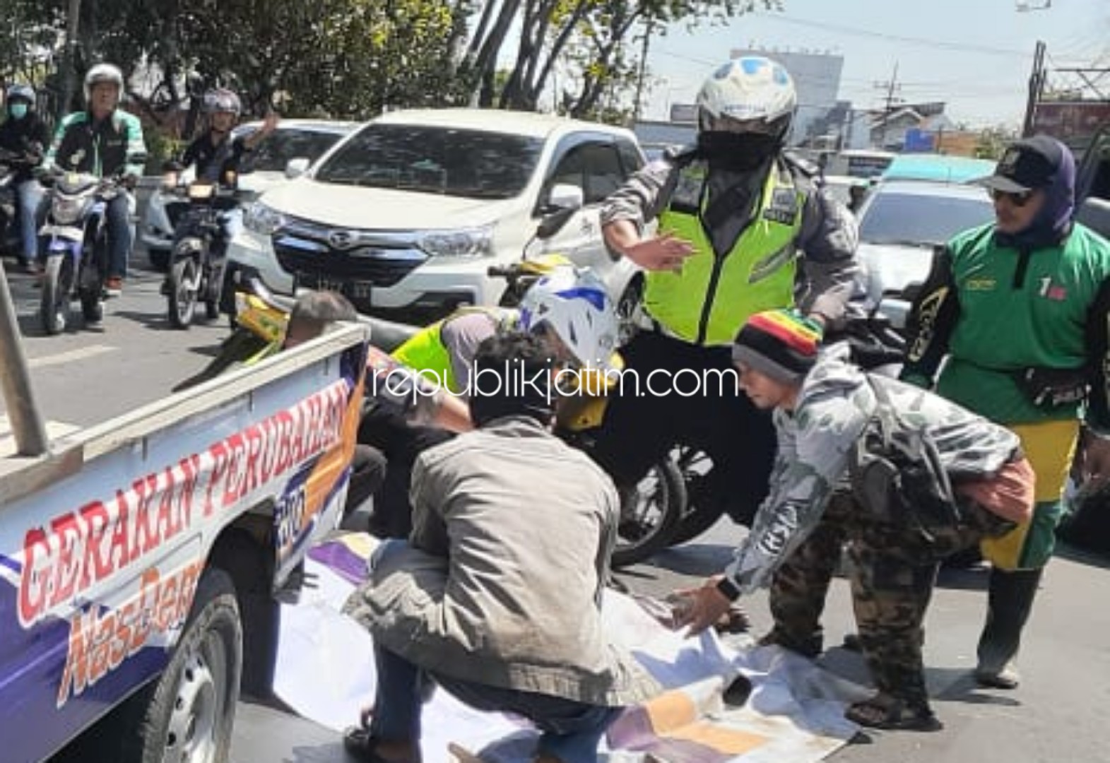 EVAKUASI - Petugas Lantas dan warga mengevakuasi jenazah pengendara Yamaha Mio, Junaedi (60) warga JL Asem Jaya, Tembok Dukuh, Bubutan Surabaya yang terlindas truk di samping Jembatan Penyebarangan, Bungurasih, Waru, Sidoarjo, Sabtu (23/11/2019).