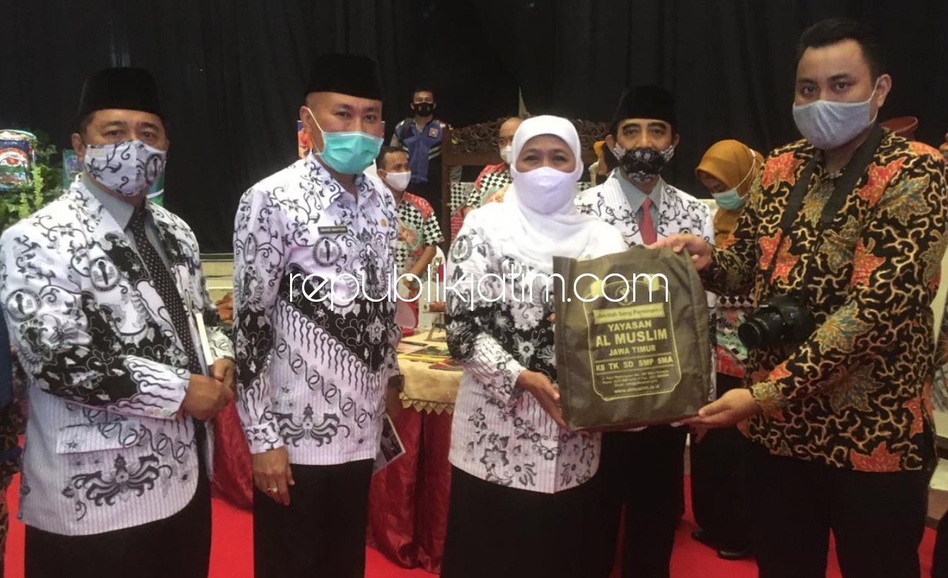 KUJUNGAN - Humas Al Muslim SMA Al Muslim, Azam Afian Dinata menyerahkan buah tangan untuk Gubernur Jatim, Khofifah Indar Parawansa usai mengunjungi stan pameran teknologi pembelajaran SMA Al Muslim di Islamic Center Surabaya, Senin (23/11/2020).