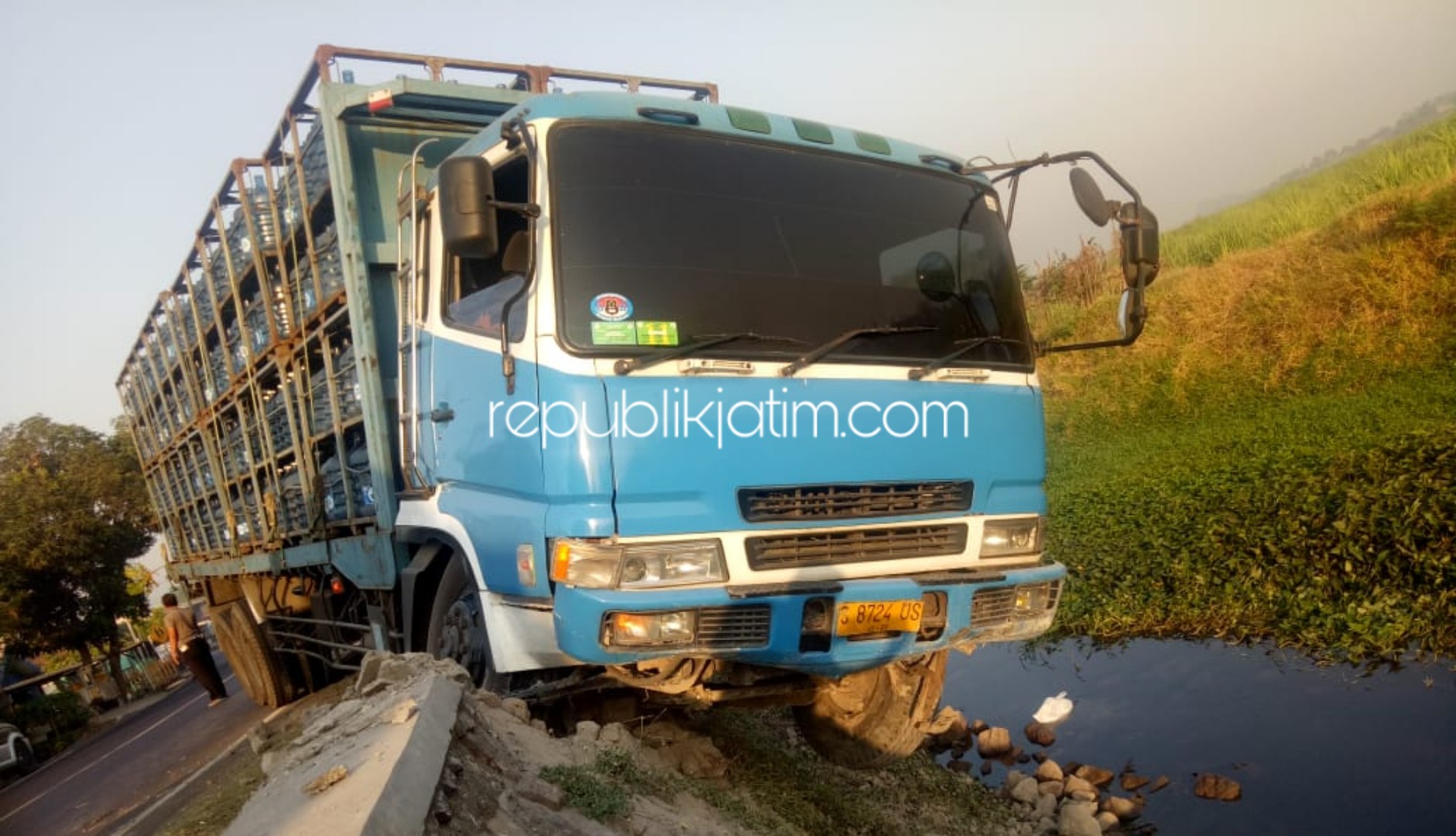 NYARIS MASUK - Sebuah truk tronton bermuatan galon menyangkut dan nyaris tercebur ke dalam sungai Desa Lajuk, Kecamatan Porong, Sidoarjo, Sabtu (23/11/2019).