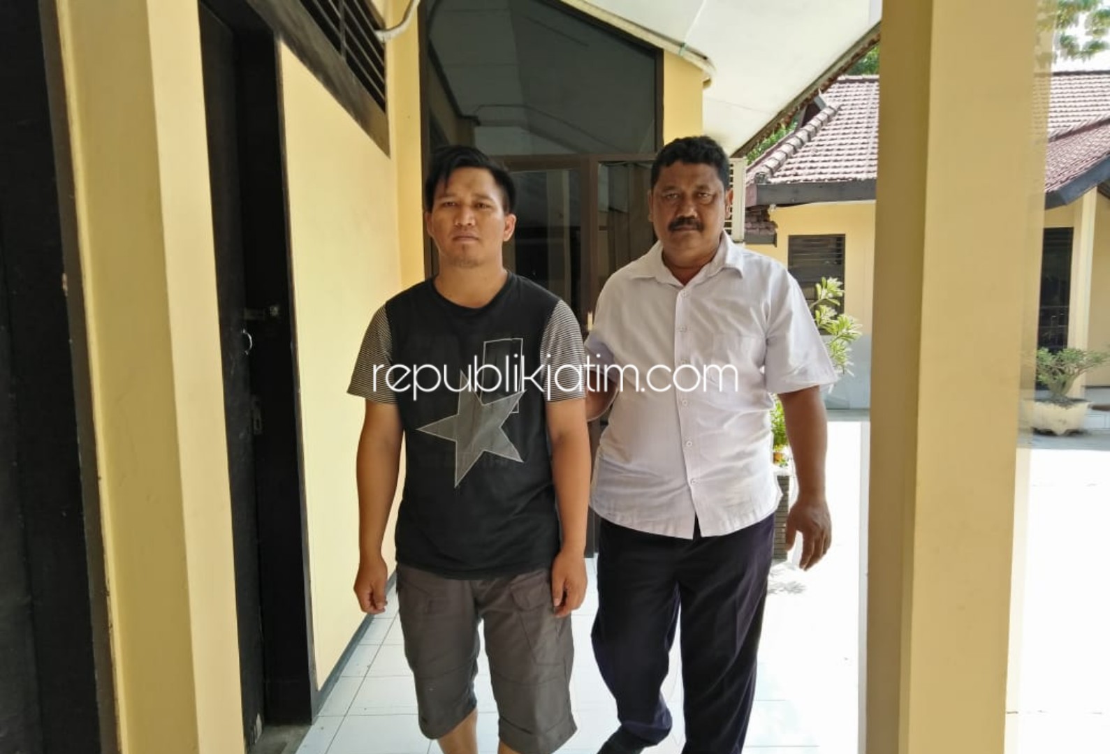 DIGELANDANG - Tersangka Fredy Permana Yuda saat digelandang anggota Polsek Porong ke dalam tahanan, Senin (25/11/2019).