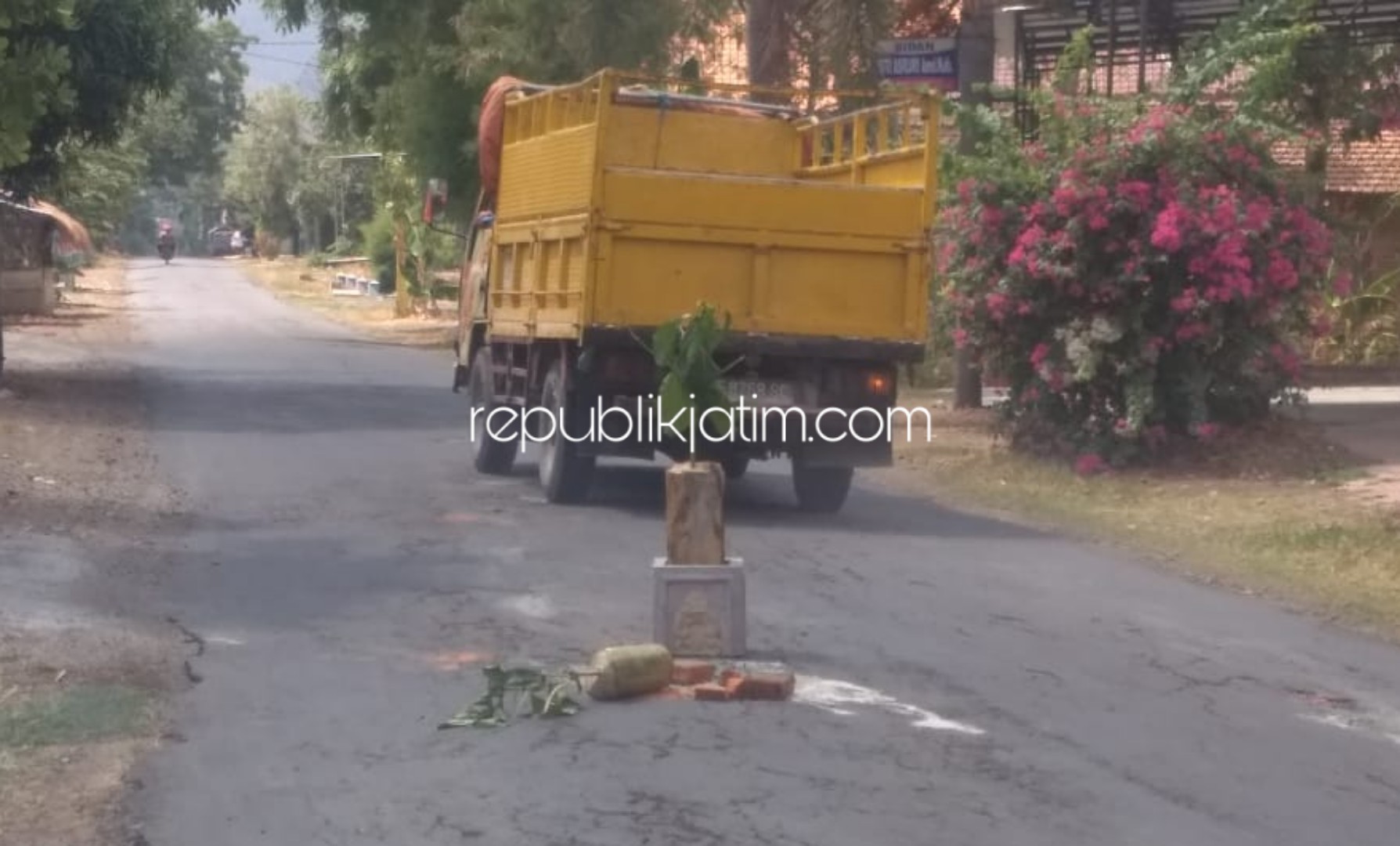 TAMBAL - Warga menambal jalan berlubang di Jalur Bungkal - Ngrayun, Ponorogo, Selasa (26/11/2019).