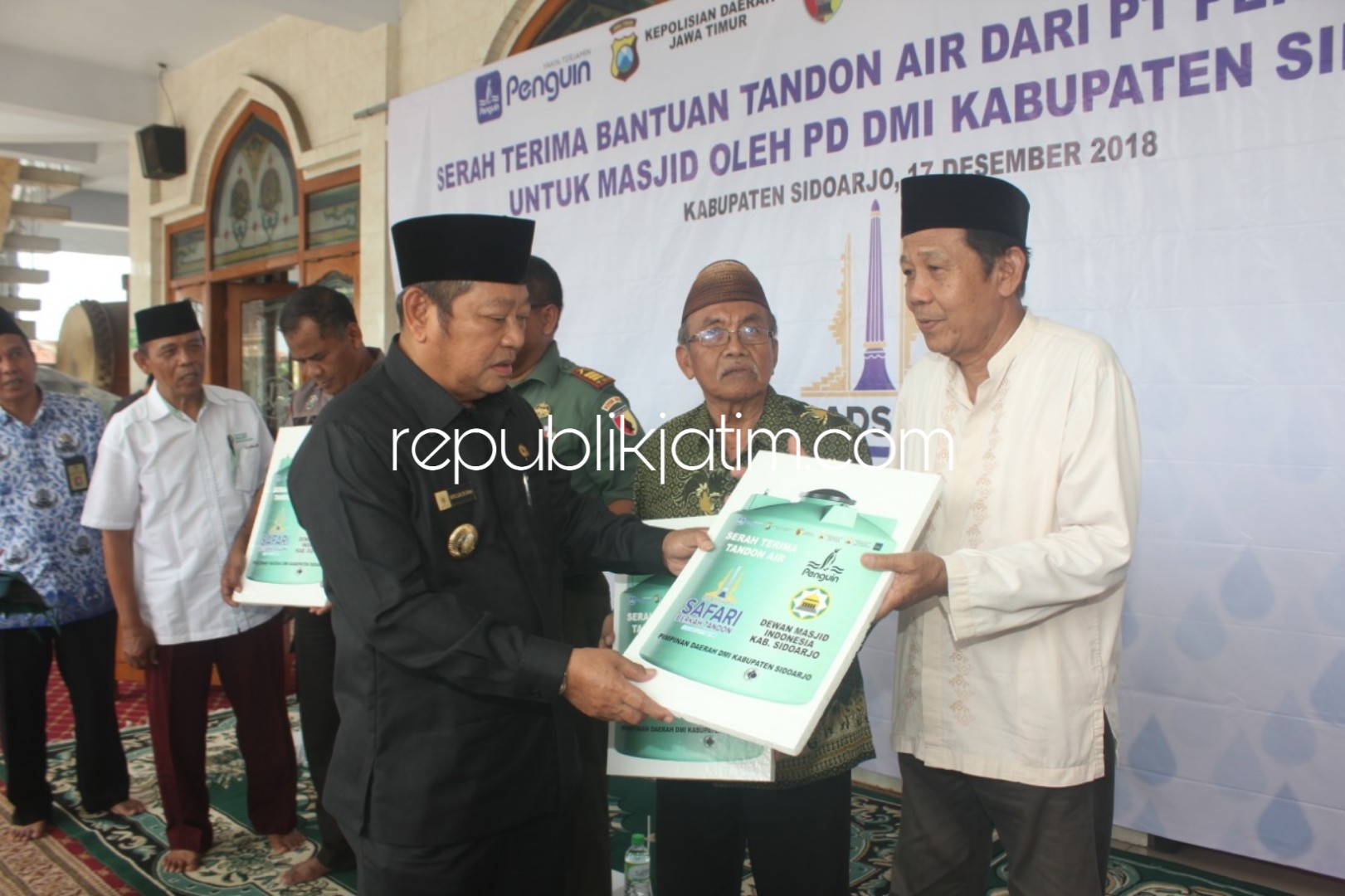 MENYERAHKAN - Bupati Sidoarjo, Saiful Ilah secara simbolis menyerahkan bantuan CRS 60 tandon air dari PT Penguin Indonesia ke takmir masjid dan lembaga yang ada di Sidoarjo, Senin (17/12/2018).
