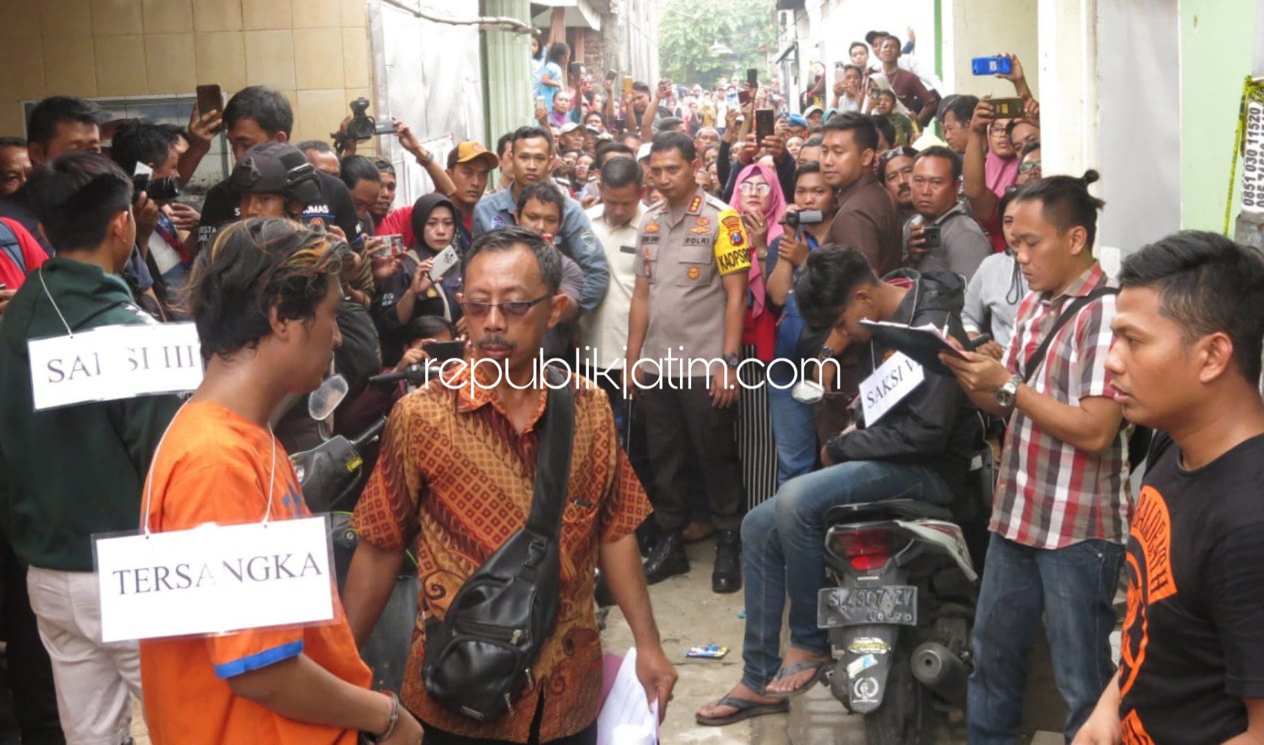 REKONSTRUKSI - Tersangka pembacokan, Miftahul Huda alias Taol (23) warga Ngelom Megare, Kelurahan Ngelom, Kecamatan Taman, Sidoarjo tertangkap di Trenggalek memeragakan belasan adegan pembunuhan terhadap rekannya, Selasa (24/12/2019).