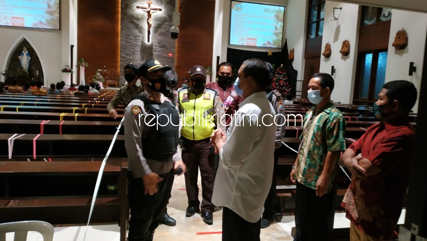 STERILISASI - Suasana sterilisasi petugas gabungan Polri, TNI dan Satpol PP Krian di malam Misa Natal Umat Katolik di Gereja Santa Monica Krian, Sidoarjo, Kamis (24/12/2020) malam.