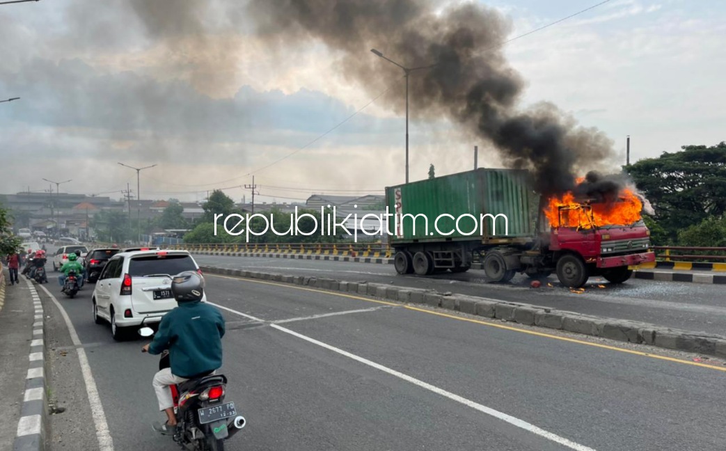 TERBAKAR - Sebuah truk bernopol L 9334 UO yang dikemudikan Dimas (21) warga Karangandong, Kecamatan Driyorejo, Gresik milik PT Prasarana Mandiri terbakar di jembatan layang Trosobo, Kecamatan Taman, Sidoarjo, Sabtu (25/12/2021).