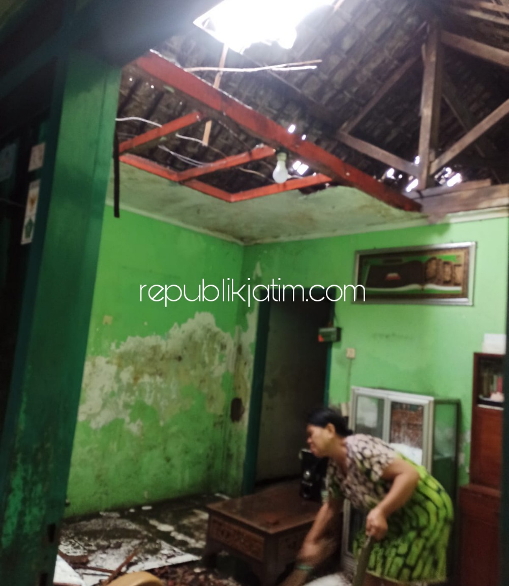 RUSAK - Salah seorang warga Desa Tambakrejo, Kecamatan Waru, Sidoarjo membersihkan puing-puing reruntuhan atap rumahnya yang tersapu angin puting beliung, Selasa (28/12/2021) sore.