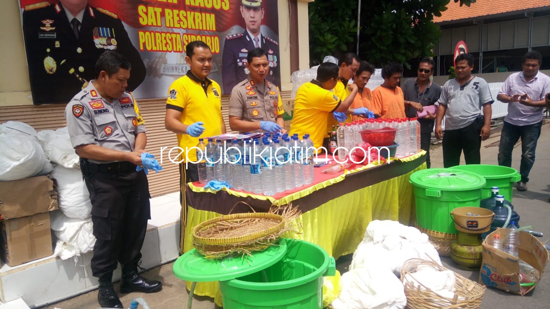 PENGOPLOS - Satuan Reskrim, Polresta Sidoarjo berhasil mengamankan 2 tersangka pengoplos miras di home industri Desa Jerukgamping, Kecamatan Krian, Sidoarjo beserta barang buktinya, Sabtu (29/12/2018).