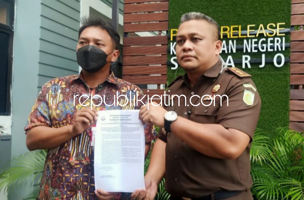 PENETAPAN - Kasi Intel Kejari Sidoarjo, Aditya Rakatama menunjukkan surat penetapan tersangka Kades Sukolegok, Kecamatan Sukodono, Sidoarjo, Rochayani saat mangkir dari panggilan tim penyidik Kejari Sidoarjo, Senin (24/01/2022).