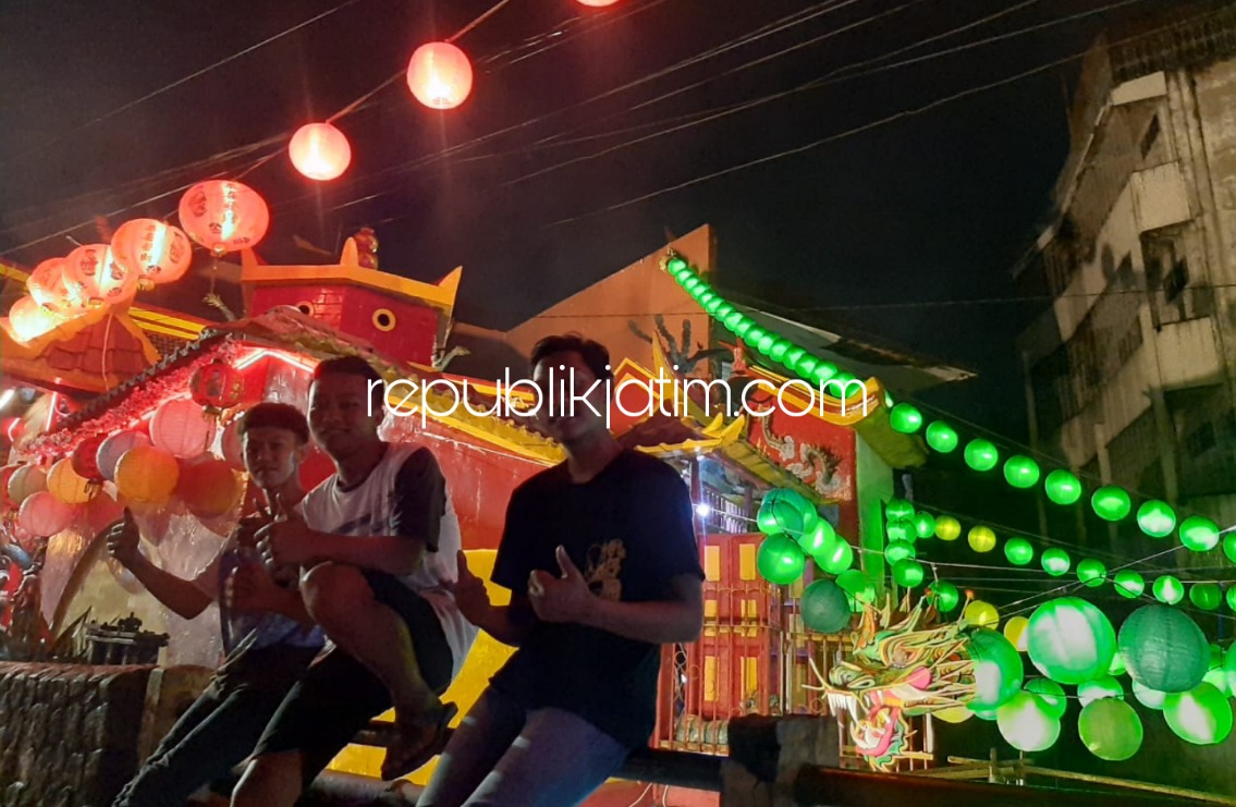KLENTENG TENG SWIE BIO - Sejumlah pengurus Klenteng Teng Swie Bio memasang Lampion Naga di atas sungai dan warga sekitar yang berswafoto depan lampion naga, Minggu (30/01/2022) malam.