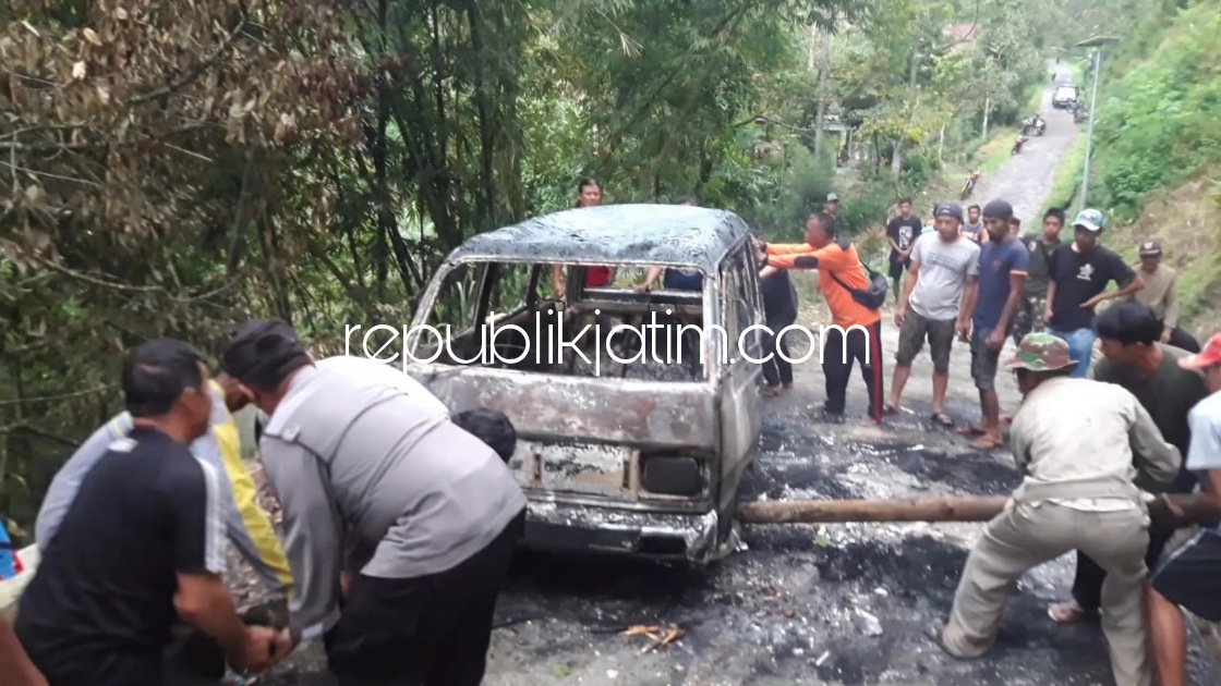 TERBAKAR - Sejumlah petugas dan warga saat mengevakuasi mobil Carry bernopol AE 1194 VK yang terbakar di Desa Gondowido, Kecamatan Ngebel, Ponorogo, Senin (31/01/2022).