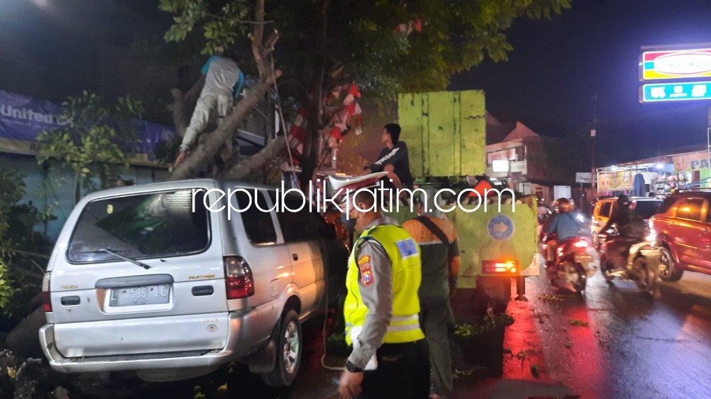 EVAKUASI - Sejumlah pohon tumbang di Jalan Raya Tropodo dan satu pohon tumbang di JL Raya Bibis, Desa Tambakkemerakan, Kecamatan Krian, Sidoarjo menimpa satu unit mobil milik warga Ponokawan, Kecamatan Krian, Selasa (22/02/2022) petang. 