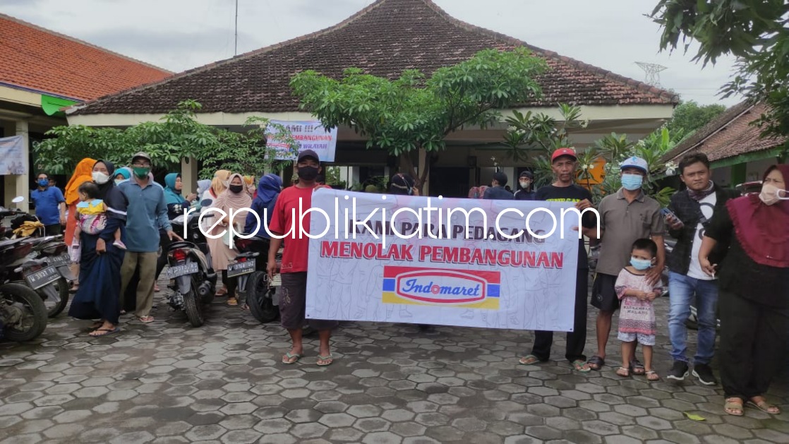 TOLAK - Sejumlah emak-emak (ibu-ibu) pemilik toko kelontong di Desa Tambakrejo, Kecamatan Krembung, Sidoarjo demo menolak pembangunan minimarket di kampungnya dengan meluruk balai desa setempat, Selasa (01/03/2022).