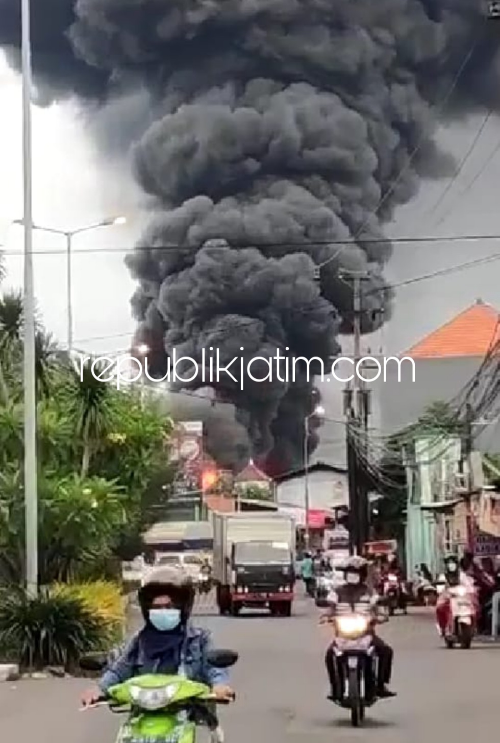 TERBAKAR - Kepulan asap membumbung tinggi akibat kebakaran pabrik sepatu CV Sweet Seventeen yang ada di Desa Kepuhkiriman, Kecamatan Waru, Sidoarjo, Rabu (09/03/2022) petang.