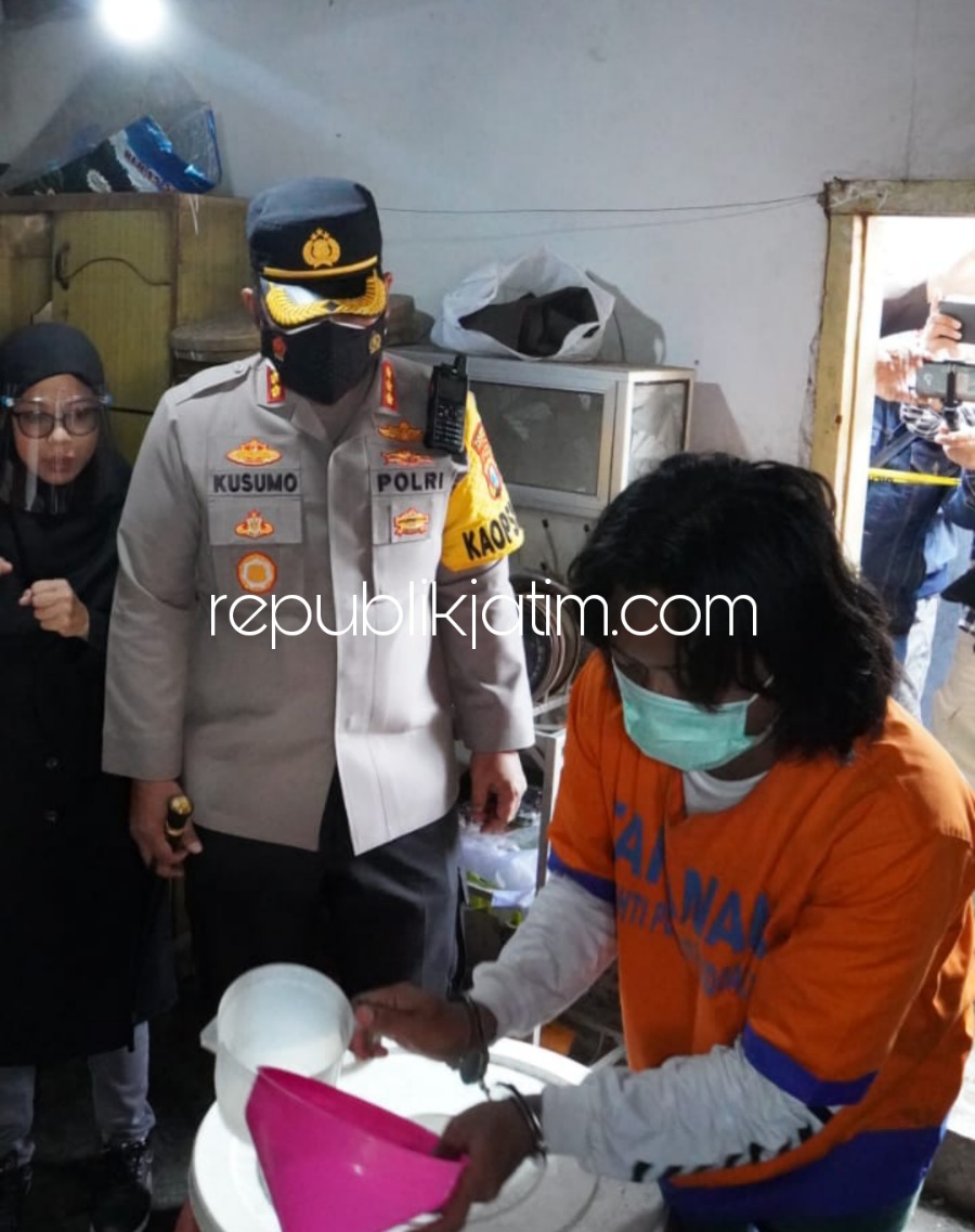 MIRAS - Tersangka IAS (41) mempraktekkan cara mengoplos Minuman Keras (Miras) di rumah kontrakannya di Desa Mojoruntut, Kecamatan Krembung, Sidoarjo disaksikan Kapolresta Sidoarjo dan tim Satuan Resnarkoba, Rabu (23/03/2022).