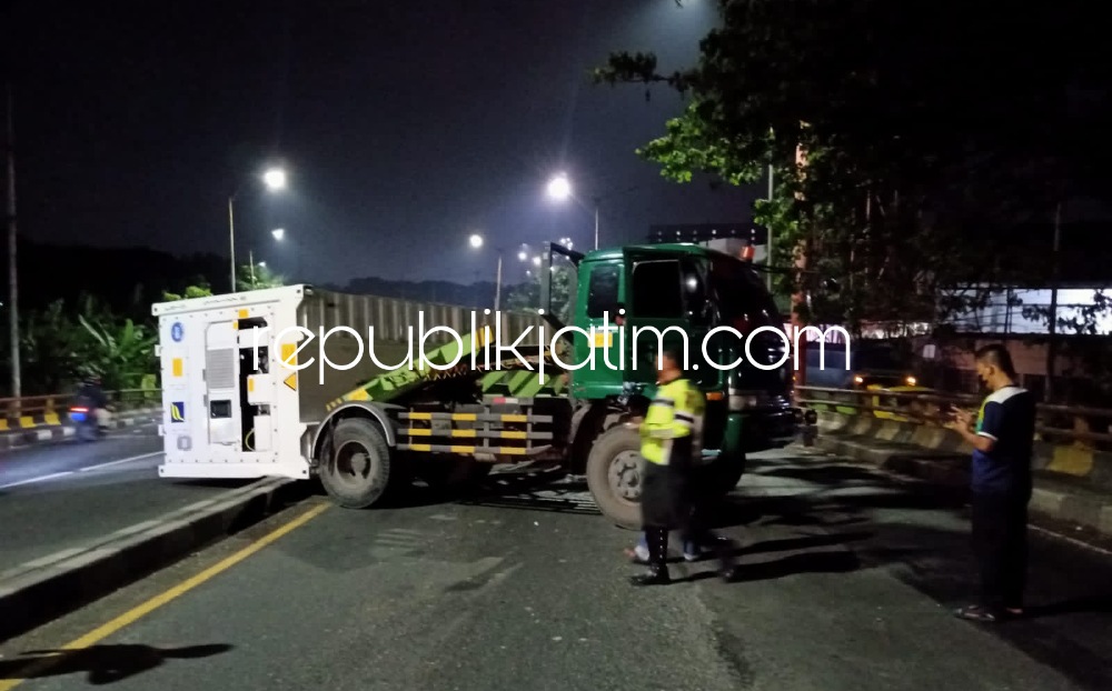 TERGULING - Truk kontainer bernopol B 9626 UED yang dikemudikan Hartono (38) warga Desa Kebonagung, Kecamatan Babat, Kabupaten Lamongan terguling di JL Raya Trosobo, Kecamatan Taman, Sidoarjo, Kamis (21/04/2022) dini hari.