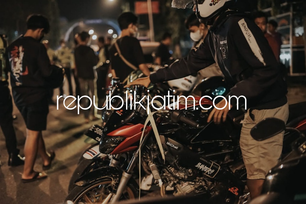 JANUR KUNING - Petugas Satuan Lantas Polres Ponorogo menyematkan Janur Kuning pada puluhan motor para pelanggar lalin yang terjaring di perbatasan Madiun - Ponorogo dan Perempatan Tambakbayan, Minggu (24/04/2022) dini hari.