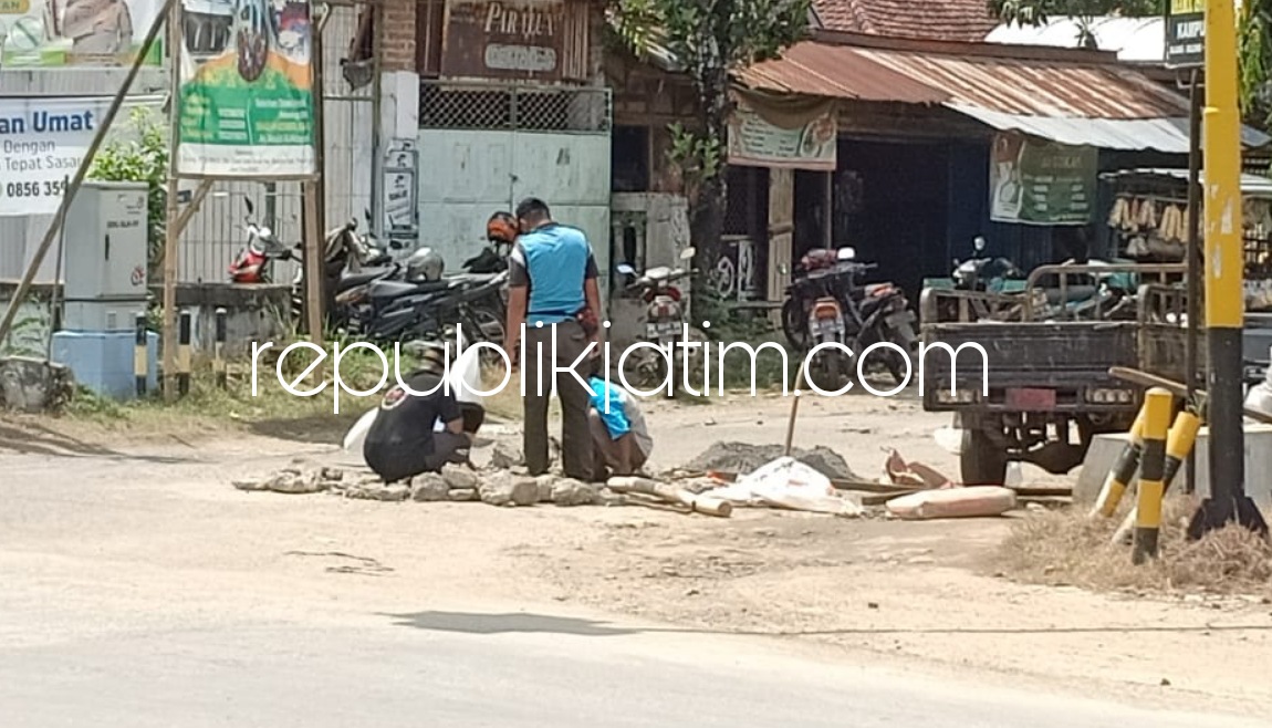 TAMBAL - Sejumlah pekerja sedang menambal atau memperbaiki jalan berlubang di Perempatan Bancar, Kecamatan Bungkal, Ponorogo, Senin (25/04/2022).