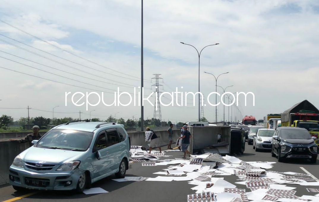 TERGULING - Truk box pengangkut kertas mengalami ban pecah hingga oleng menabrak mobil Xenia dan terguling di JL Tol Porong - Gempol, Sidoarjo serta memicu kemacetan, Rabu (01/06/2022).