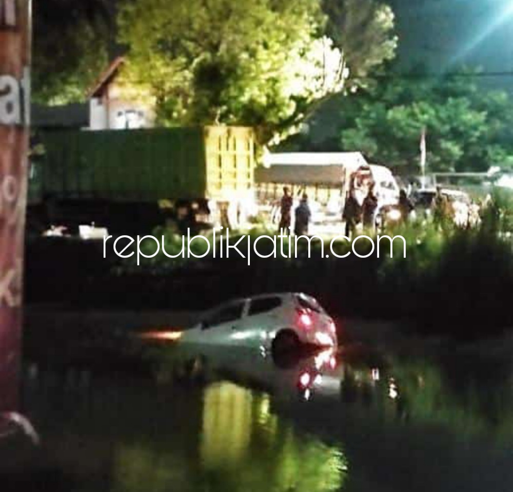 TERJUN - Mobil Daihatzu Ayla bernopol S 1801 BT yang dikemudikan Aviudin Virdian (39) warga JL Balasklumprik, Kecamatan Wiyung, Kota Surabaya masuk ke Sungai Balongbendo, Sidoarjo hingga menyebabkan sopir terluka, Selasa (07/06/2022) malam.
