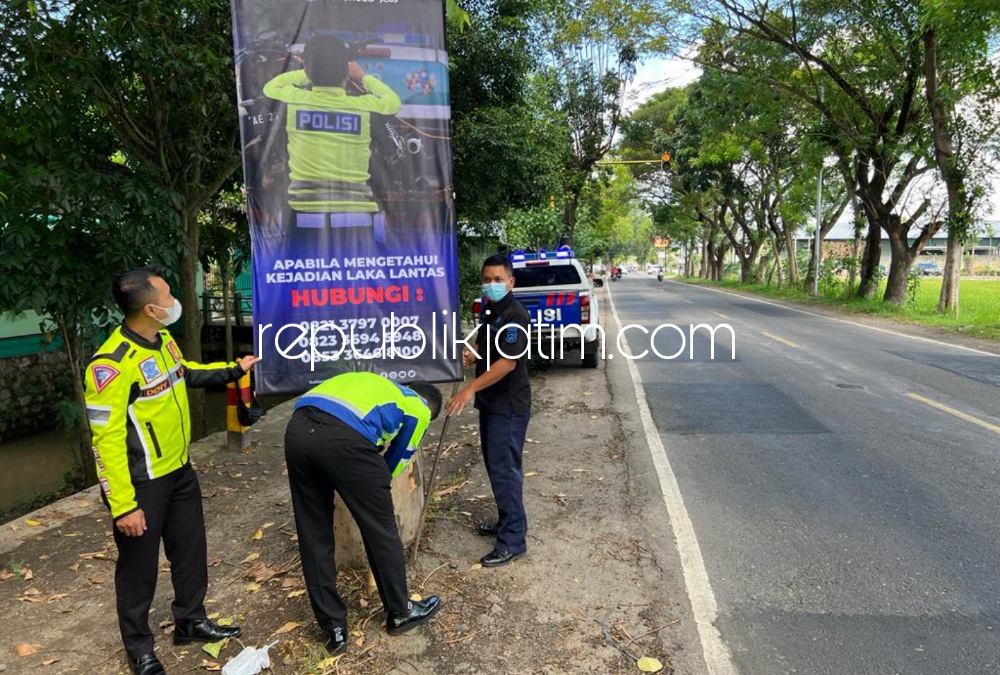 BANNER- Anggota Satuan Lantas Polres Ponorogo memasang banner di sejumlah jalur tengkorak yang ditengarai rawan kecelakaan, Kamis (30/06/2022). 