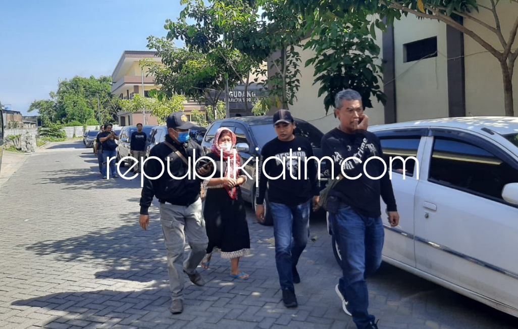 ISTRI KORBAN - Ny Wiwin Winarsih (34) istri juragan rosok korban penembakan, M Sabar (38) saat di Polresta Sidoarjo, Jumat (01/07/2022) sore. Insert foto koran penembakan M Sabar.