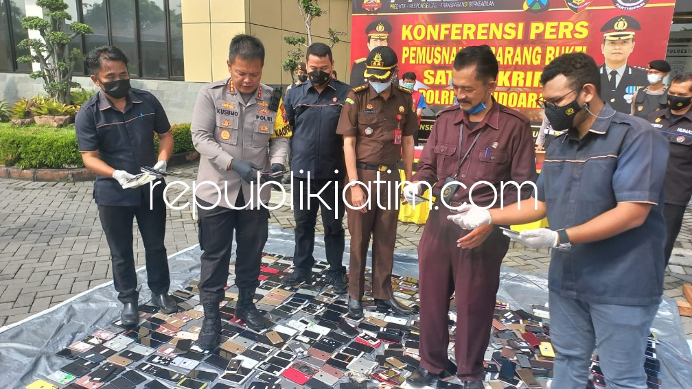 MUSNAHKAN - Kapolresta Sidoarjo Kombes Pol Kusumo Wahyu Bintoro memimpin pemusnahan barang bukti hand phone (HP) hasil reparasi hingga terlihat seperti baru di Polresta Sidoarjo, Rabu (06/07/2022).