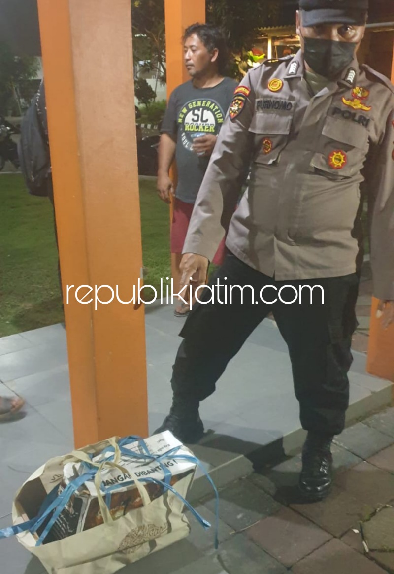 BAYI - Petugas menunjukkan sesosok mayat bayi perempuan saat ditemukan di dalam bungkusan handuk biru di Sukodono, Sidoarjo, Minggu (30/10/2022).