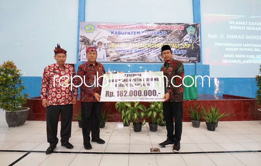 BANTUAN - Bupati Sidoarjo Ahmad Muhdlor Ali secara simbolis menyerahkan bantuan uang tunai Rp 182 juta untuk guru dan siswa korban amukan puting beliung diserahkan di Aula SMPN 2 Sidoarjo, Kamis (03/11/2022). 