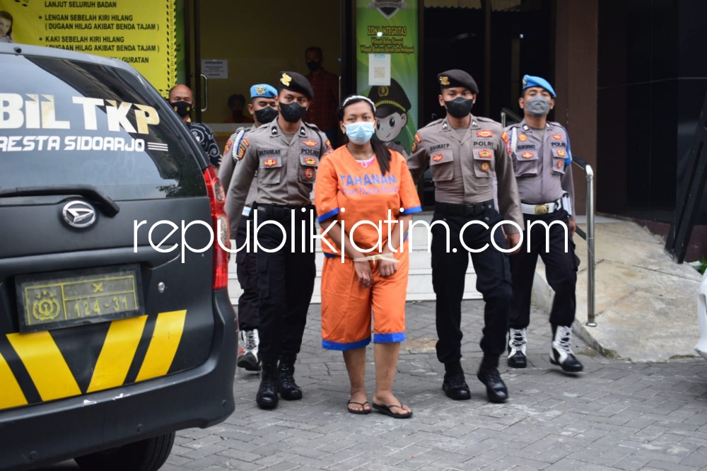 GELANDANG - Ibu pembuang bayi, WIC (25) Pembantu Rumah Tangga (PRT) asal Desa Tanggung, Kecamatan Turen, Kabupaten Malang digelandang petugas Polresta Sidoarjo beserta barang buktinya saat dipamerkan ke kru media, Jumat (04/11/2022) sore.