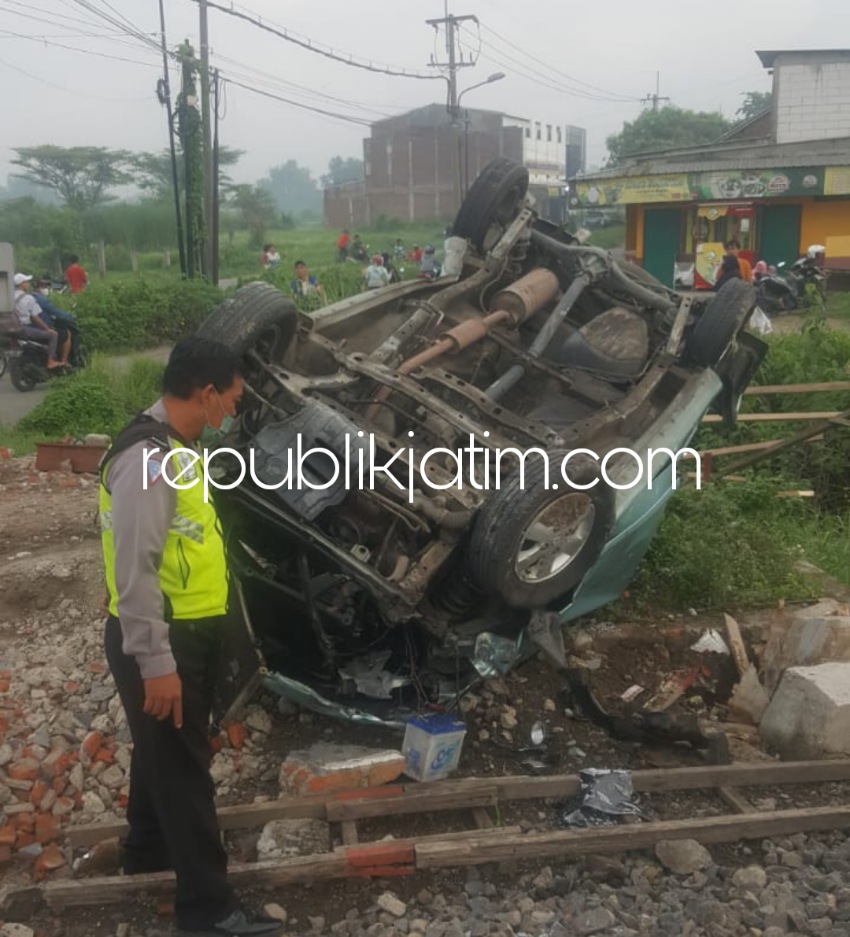TERGULING - Sebuah mobil Toyota Avanza terguling usai disambar Kereta Api (KA) di perlintasan tanpa palang pintu Desa Tawangsari, Kecamatan Taman, Sidoarjo, Minggu (13/11/2022).