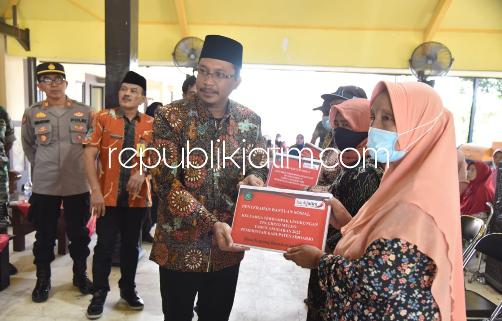 BANSOS - Bupati Sidoarjo, Ahmad Muhdlor Ali didampingi Kepala DLHK Pemkab Sidoarjo, M Bahrul Amiq menyerahkan bansos uang tunai kepada ribuan warga di 4 desa di Balai Desa Kupang, Kecamatan Jabon, Sidoarjo, Jumat (09/12/2022).