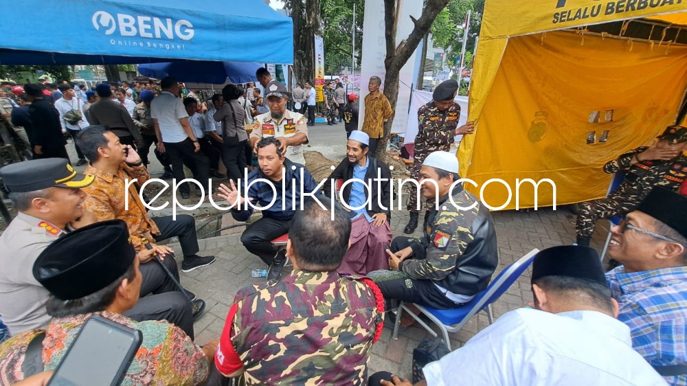 PIJAT - Bupati Sidoarjo Ahmad Muhdlor Ali sejenak melepas lelah sembari duduk santai dan dipijat anggota Banser, Mbah Jib di Parkir Timur Gelora Delta Sidoarjo, Senin (06/02/2023).